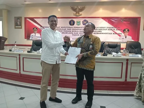 Sekretaris Daerah Kabupaten Malang Dr Ir Wahyu Hidayat MM menyerahkan SK pembentukan Unit Layanan Disabilitas Bidang Ketenagakerjaan kepada Kepala Dinas Tenaga Kerja Kabupaten Malang Yoyok Wardoyo.(ira tabika/MPM)